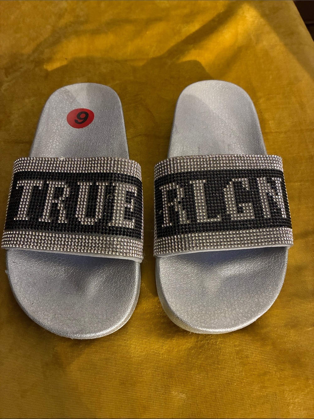 True Religion Silver Rhinestone Slide Sandals with Black Lettering
